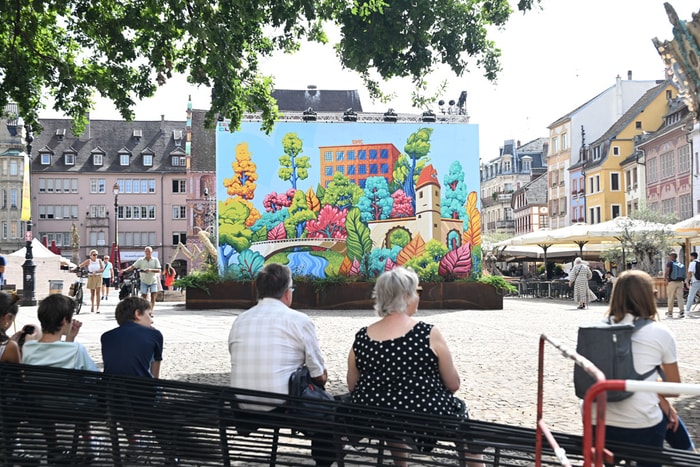 La fresque monumentale de huit mètres de haut, réalisée par le Mulhousien Edouard Blum, reprend, sur son coté pile, des lieux emblématiques de la ville.